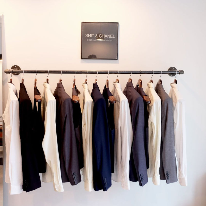 Kleiderstange für Montage an der Wand aus dunklen Eisenrohren für Jacken in Kleidungsgeschäft
