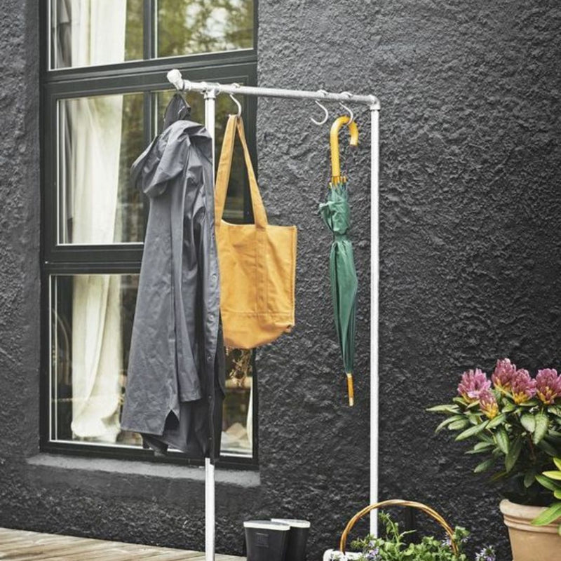 Frei stehender Kleiderständer aus silbernen Eisenrohre für Jacken Taschen und Regenschirme im Außenbereich