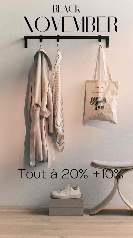 Minimalistischer Eingangsbereich mit Mantel, Schal, Stofftasche, Schuhen auf Box und Hocker vor weißer Wand