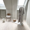frei stehender Kleiderständer mit weißer Bodenplatte zum Aufhängen von Bademänteln im Badzimmer