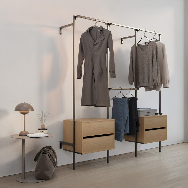 Minimalistisches Schlafzimmer mit offener Kleiderstange, dezenter Beleuchtung und neutraler Deko in hellem Raum