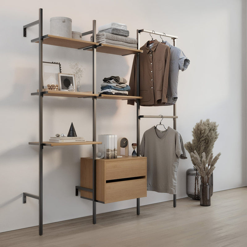 Hellgraue Wand mit modernem, offenem Regal aus Metall und Holz, Kleidungsstücke und Dekoobjekte darauf arrangiert