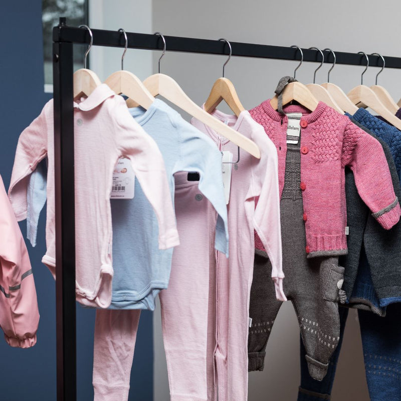 frei stehender Kleiderständer aus schwarzen Eisenstangen zur Präsentation von Kleidung für Kinder und Erwachsenen