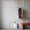 Deckenmontierte Kleiderstange aus weißen Eisenrohren als Garderobe mit moderner Einrichtung