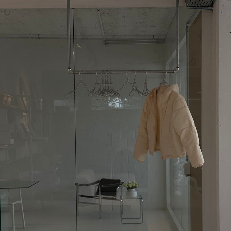 Kleiderstange für Montage an der Decke aus modernen silbernen Eisenrohren als Garderobe fürs Büro