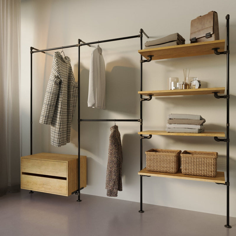 Offene Garderobe mit Holzablagen, Hängemöglichkeiten für Kleidung und zwei geflochtenen Körben vor hellem Hintergrund