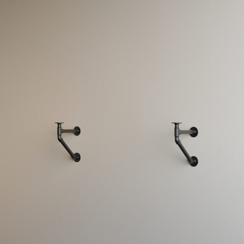 Heller Wandhintergrund mit zwei schwarzen Metallhalterungen im industriellen Stil symmetrisch angebracht