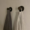 Kleine Wandhaken aus dunklen Wasserrohren für Handtücher im Badezimmer oder  der Küche